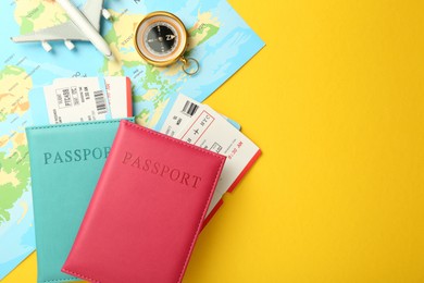 Photo of Passports with tickets, map, compass and airplane model on yellow background, flat lay. Space for text