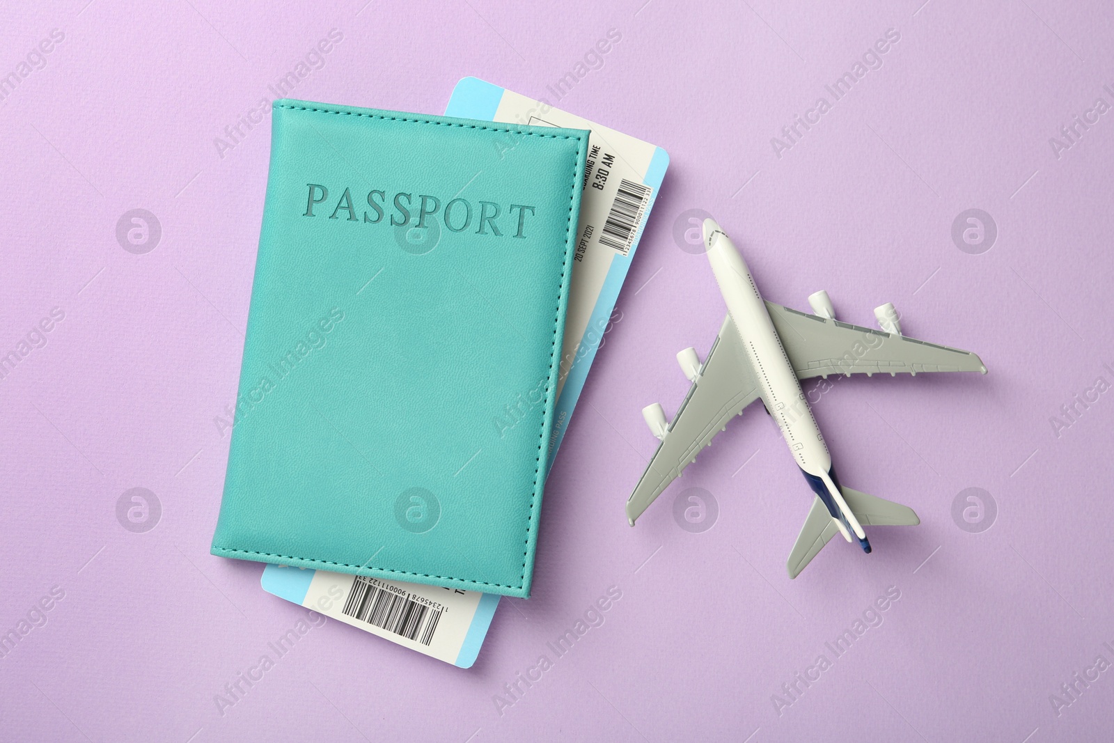 Photo of Passport with ticket and airplane model on lilac background, flat lay