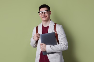 Photo of Student with laptop and backpack on olive background