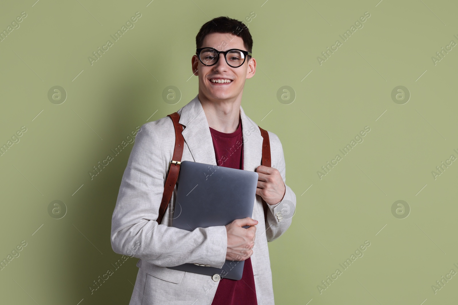 Photo of Student with laptop and backpack on olive background