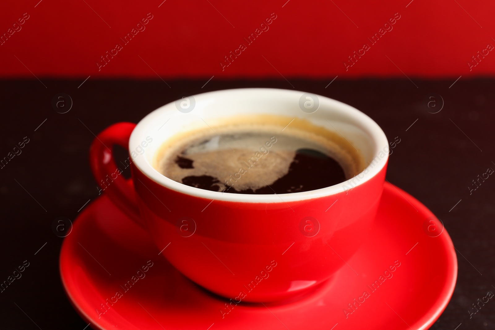 Red cup with coffee on black table, closeup Photo of Red cup with coffee on black table, closeup