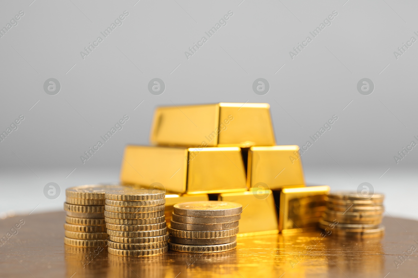 Photo of Gold bars and coins on table, closeup