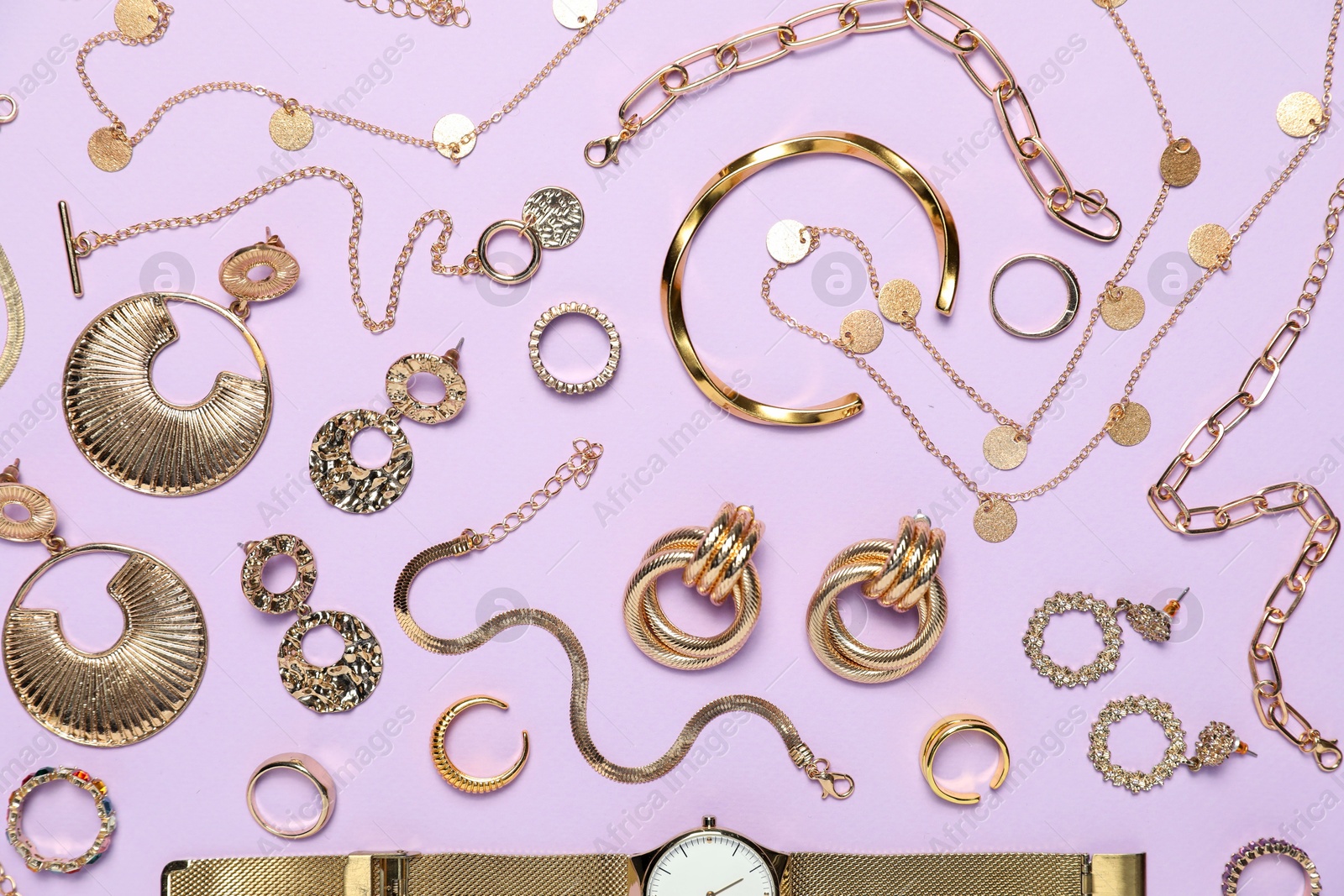 Photo of Flat lay composition with golden jewelry and watch on violet background