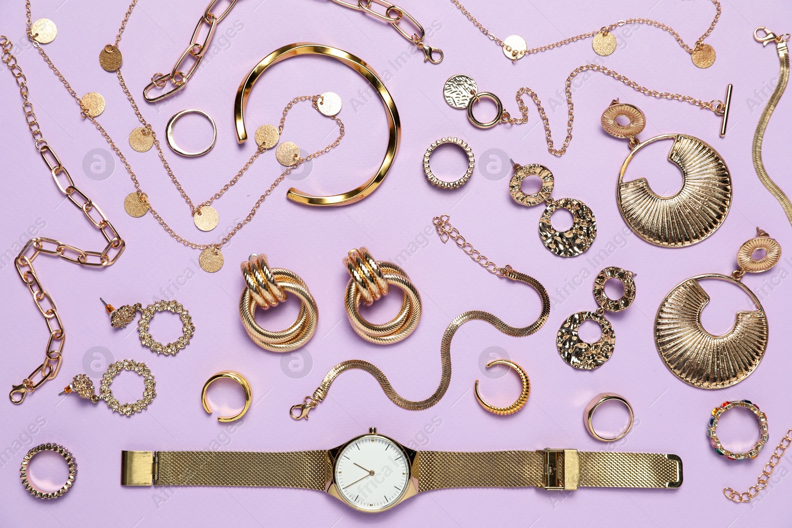 Photo of Flat lay composition with golden jewelry and watch on violet background