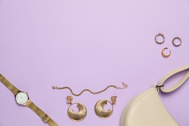 Photo of Flat lay composition with golden jewelry and accessories on violet background, space for text