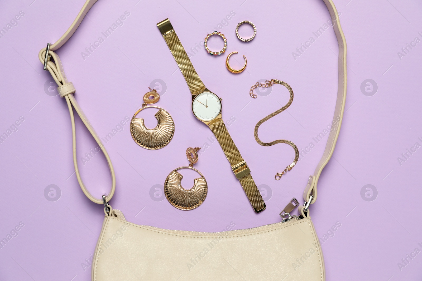 Photo of Flat lay composition with golden jewelry and accessories on violet background