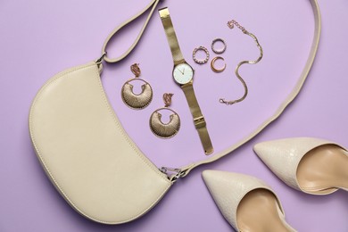 Photo of Flat lay composition with golden jewelry, shoes and accessories on violet background