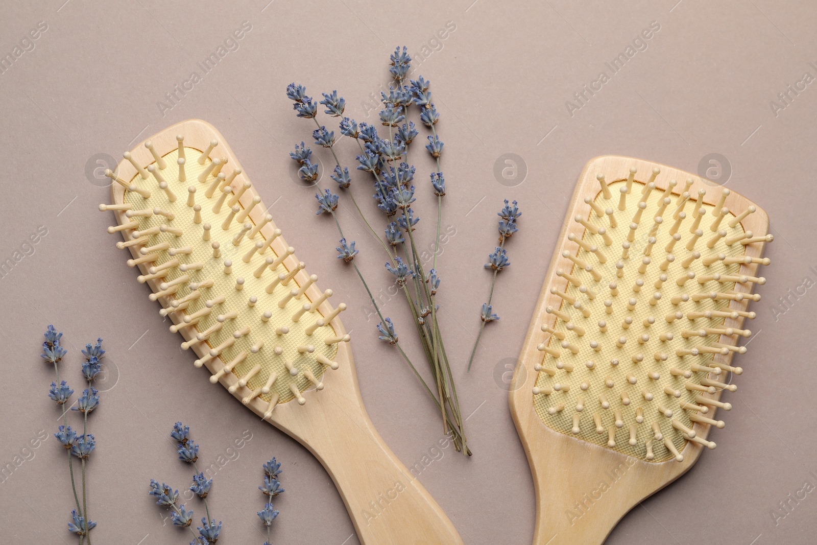 Photo of Wooden hair brushes and lavender flowers on color background, flat lay