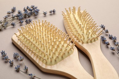 Photo of Wooden hair brushes and lavender flowers on color background, closeup