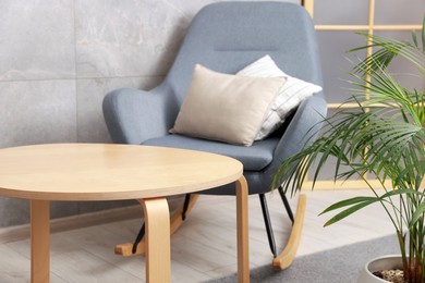 Photo of Stylish coffee table and rocking chair at home