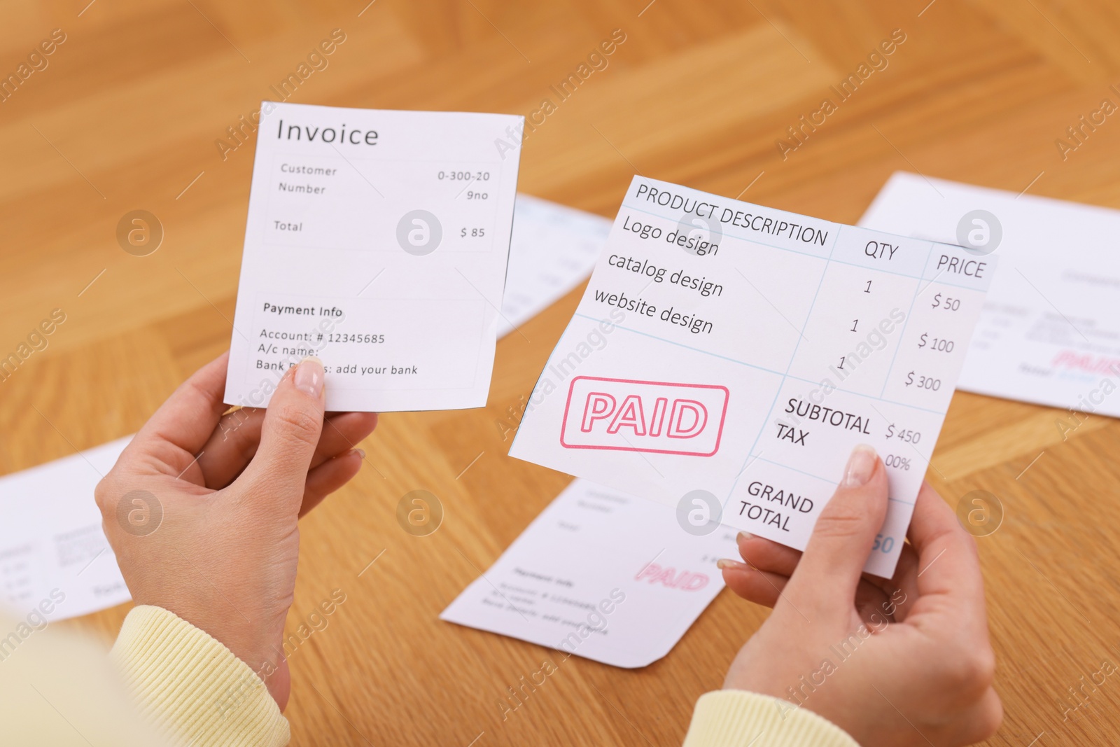 Photo of Paying bills. Woman with different invoices at wooden table indoors, closeup