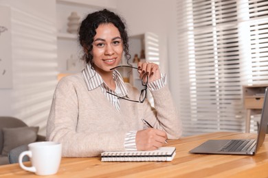 Photo of Beautiful woman working on laptop at desk in home office