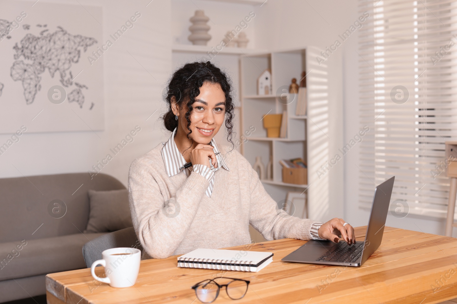 Photo of Beautiful woman working on laptop at desk in home office