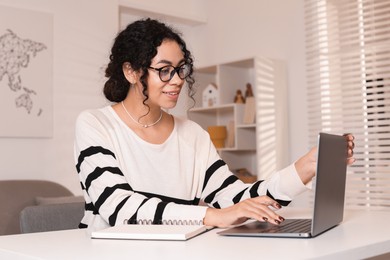 Photo of Beautiful woman working on laptop at desk in home office