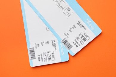 Photo of Travel agency. Flight tickets on orange background, top view