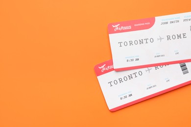 Photo of Travel agency. Flight tickets on orange background, top view. Space for text