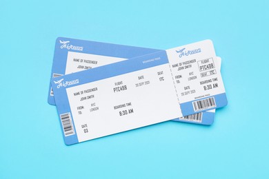 Photo of Travel agency. Flight tickets on light blue background, top view