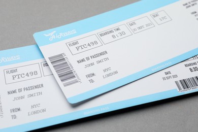 Photo of Travel agency. Flight tickets on grey background, closeup