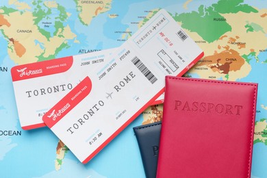 Photo of Travel agency. Flight tickets and passports on world map, flat lay