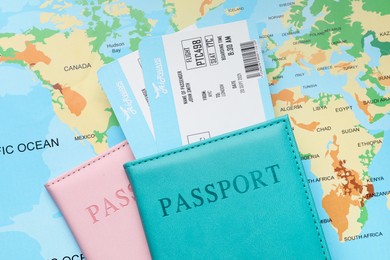 Photo of Travel agency. Flight tickets and passports on world map, flat lay