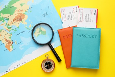 Photo of Travel agency. Flat lay composition with flight tickets on yellow background