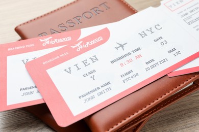 Photo of Travel agency. Flight tickets and passports on wooden table, closeup