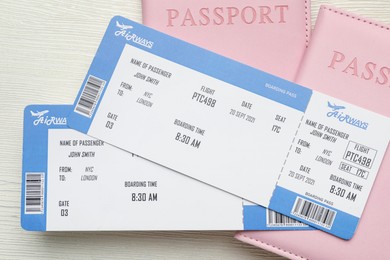 Photo of Travel agency. Flight tickets and passports on light wooden table, top view