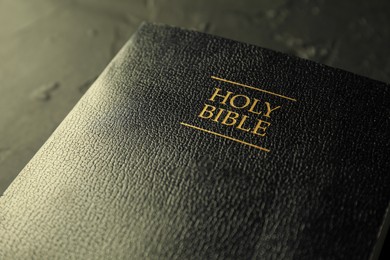 Photo of Hardcover Holy Bible in English language on black table, closeup