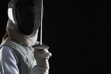 Photo of Fencer with epee on black background, space for text