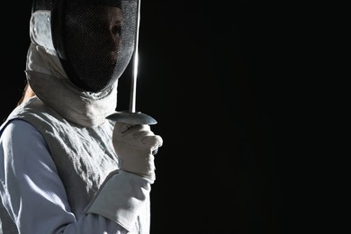 Photo of Fencer with epee on black background, space for text