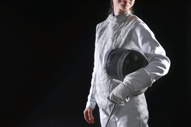 Photo of Fencer with epee on black background, closeup. Space for text