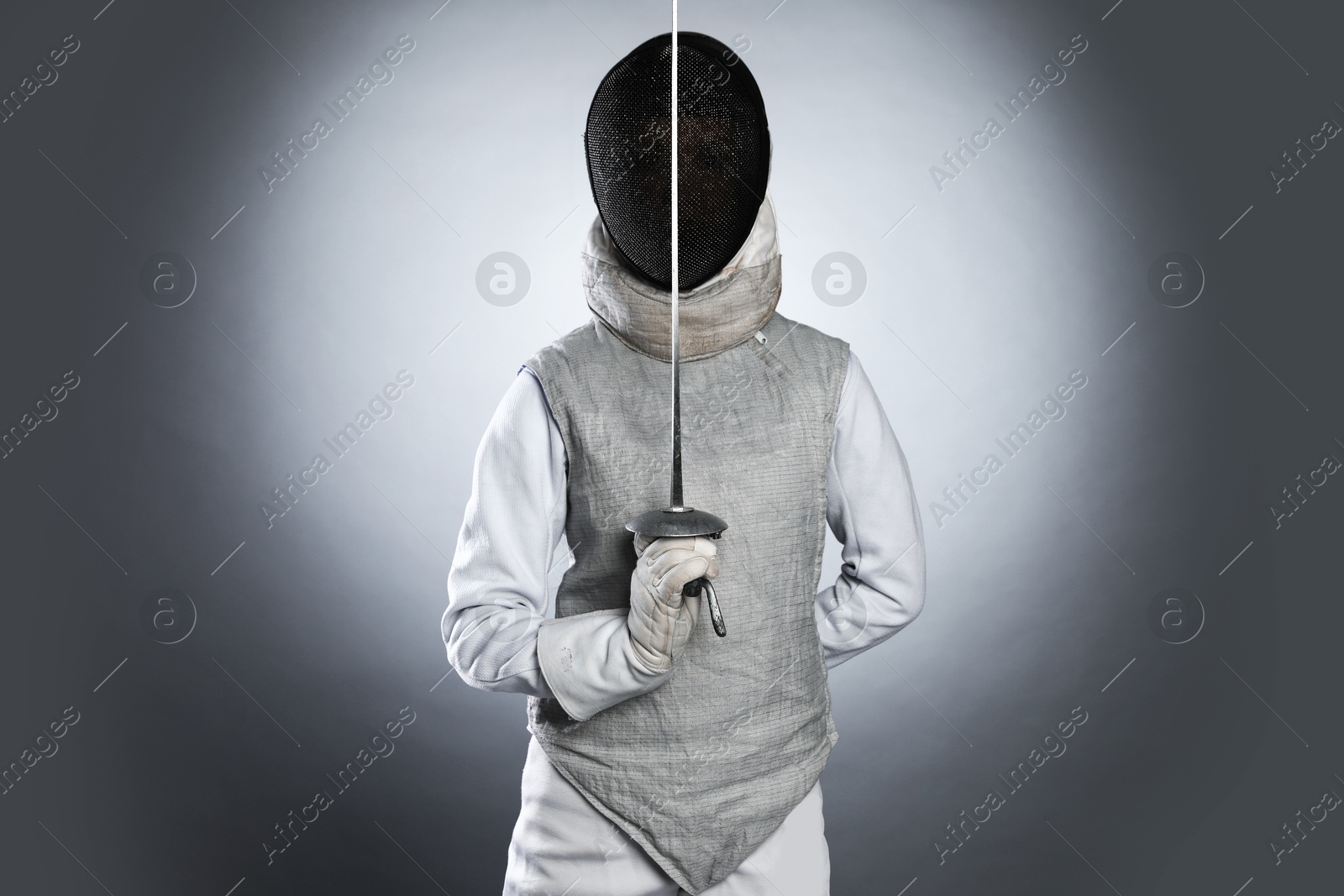 Photo of Fencer with epee on gray background. Combat sport