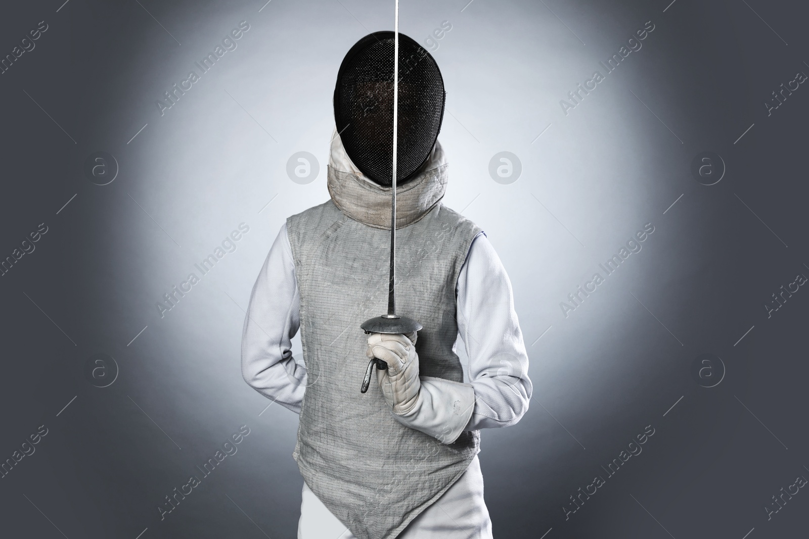 Photo of Fencer with epee on gray background. Combat sport