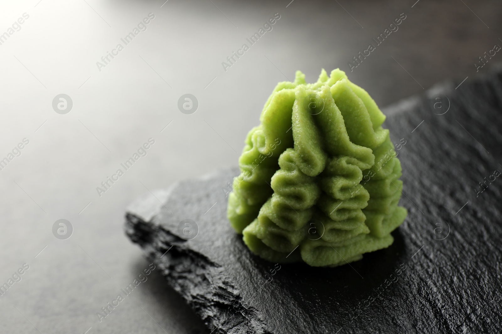 Photo of Hot wasabi paste on grey table, closeup. Space for text