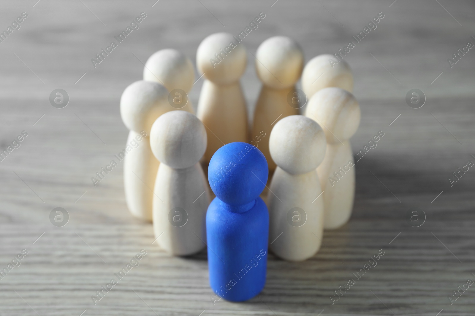 Photo of Human resources concept. Blue figure among wooden ones on table, closeup