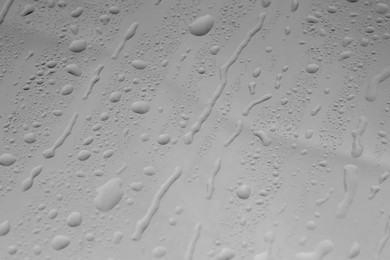 Water drops on grey glass surface, closeup