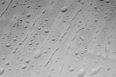 Water drops on grey glass surface, closeup