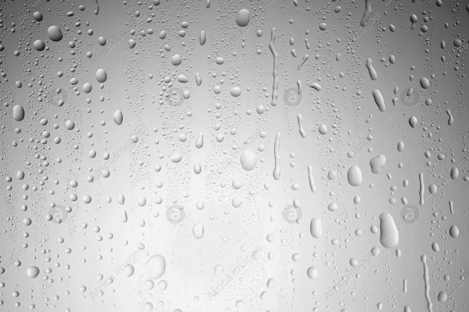 Photo of Water drops on light grey glass surface, top view