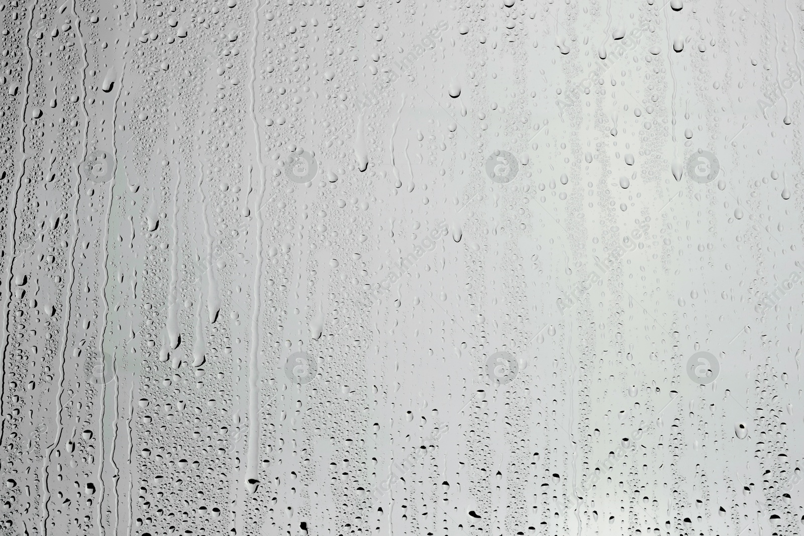 Photo of Water drops on grey glass surface, top view