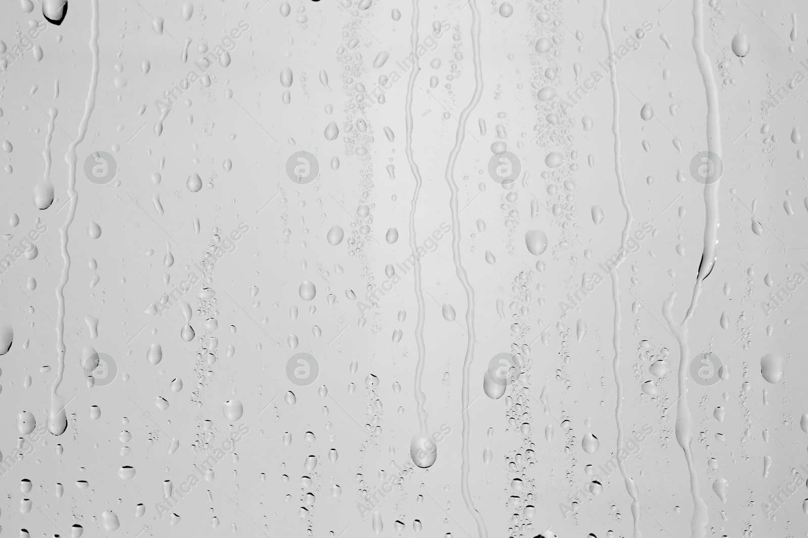 Photo of Water drops on light grey glass surface, top view