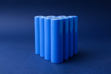 Photo of Many AA cell batteries on blue background, closeup