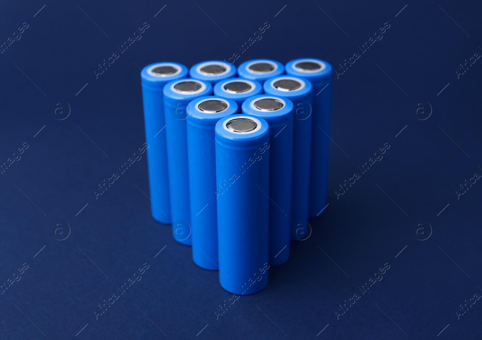 Photo of Many AA cell batteries on blue background, closeup