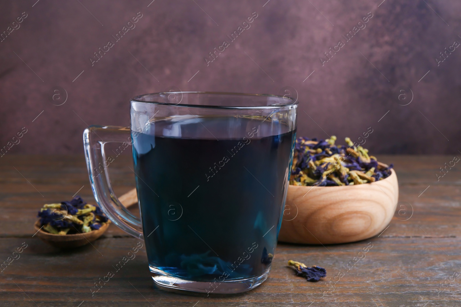 Photo of Delicious butterfly pea flower tea on wooden table, closeup