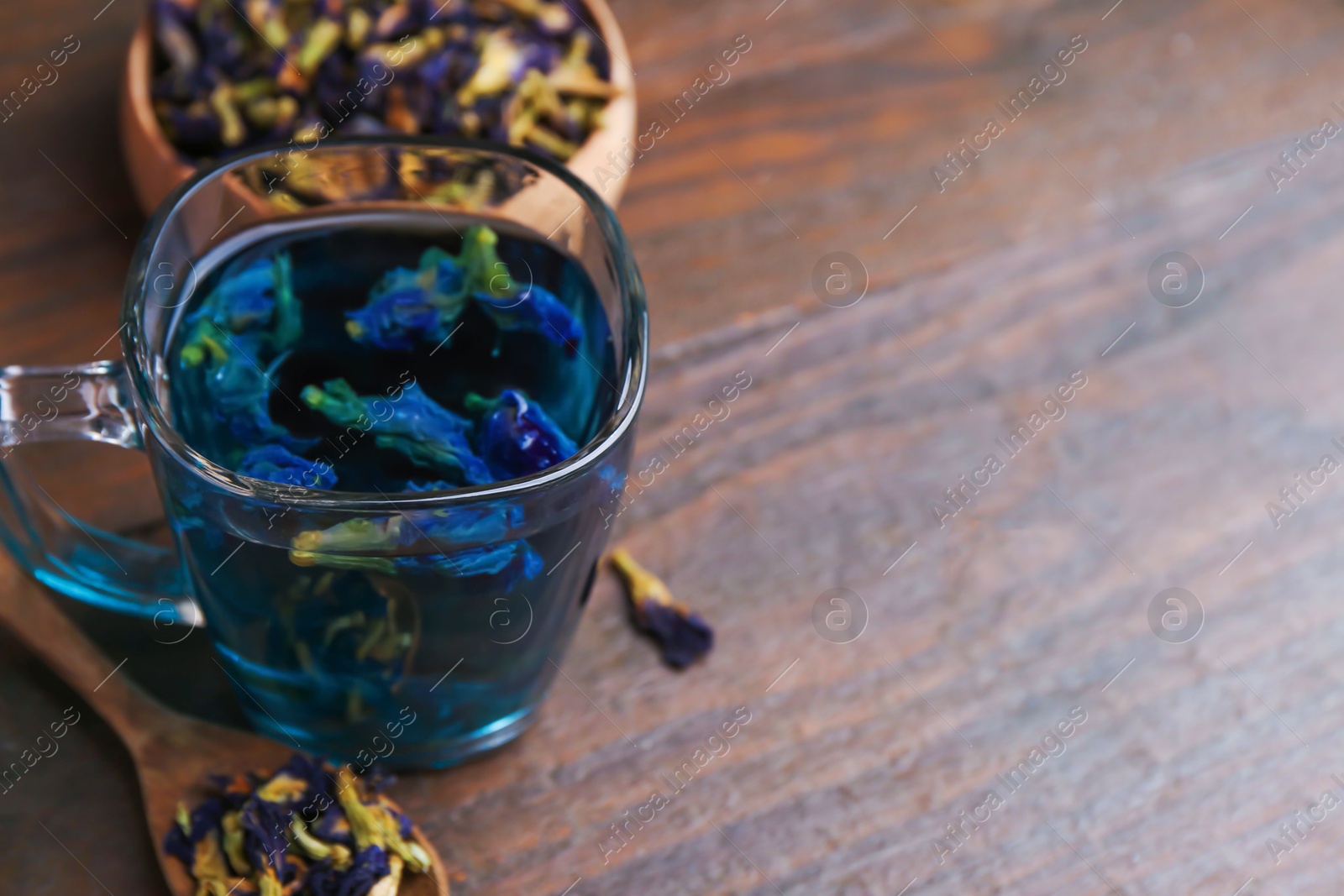 Delicious butterfly pea flower tea on wooden table. Space for text Photo of Delicious butterfly pea flower tea on wooden table. Space for text