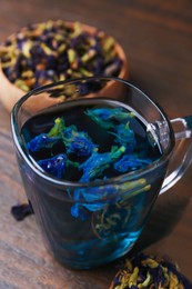 Photo of Delicious butterfly pea flower tea on wooden table, closeup