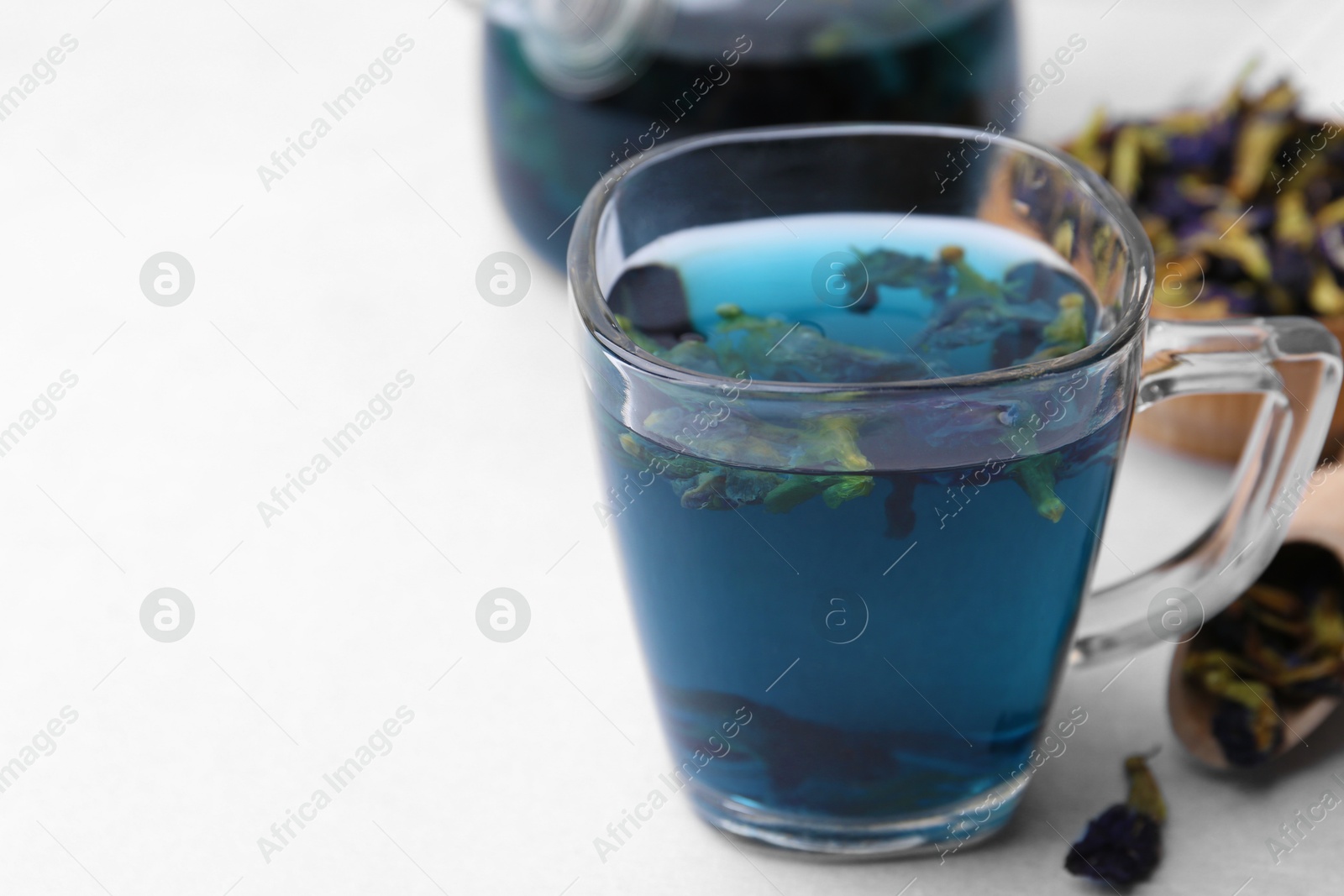 Photo of Delicious butterfly pea flower tea on white table, closeup. Space for text