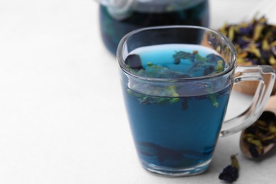 Photo of Delicious butterfly pea flower tea on white table, closeup. Space for text