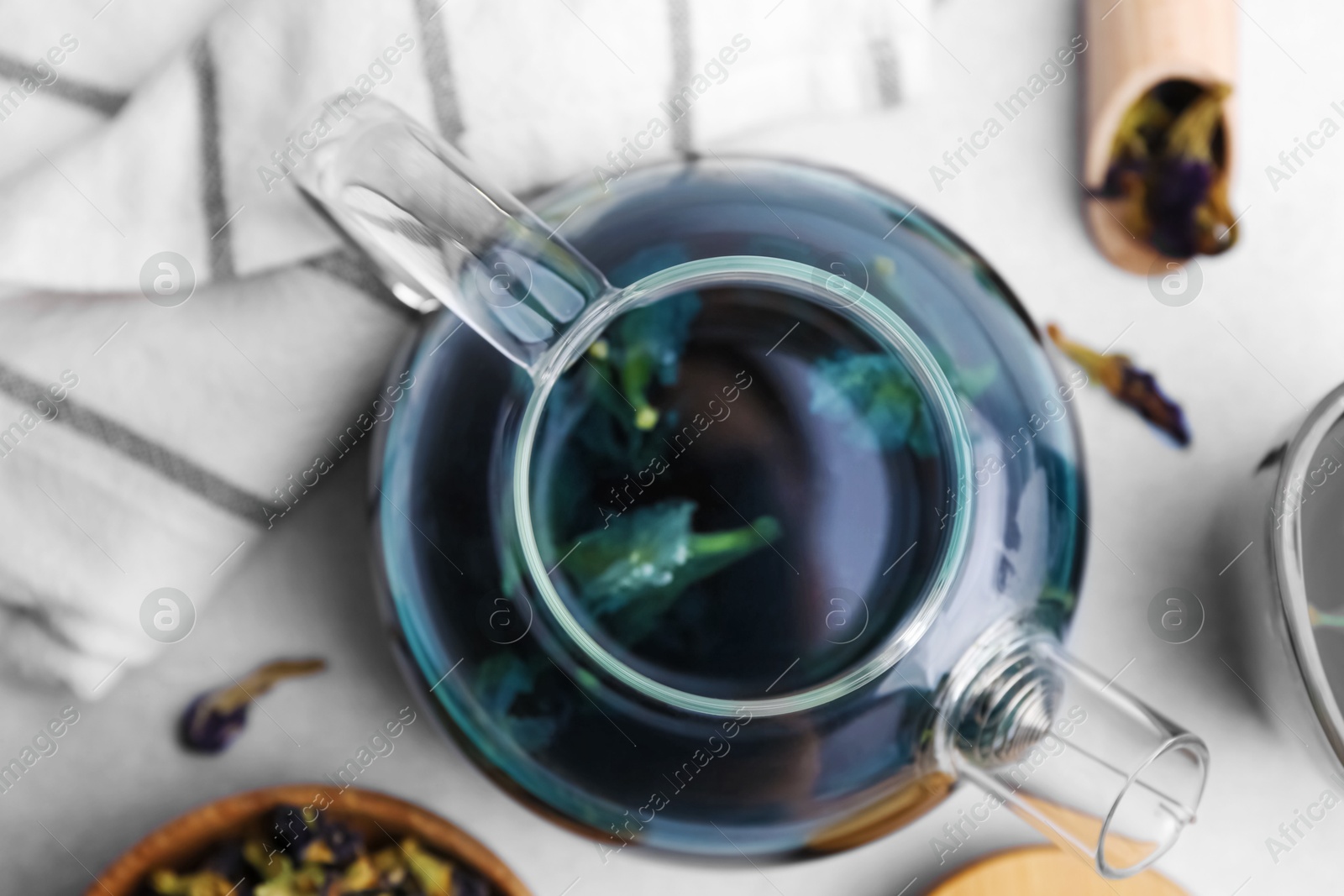 Photo of Delicious butterfly pea flower tea on white table, flat lay