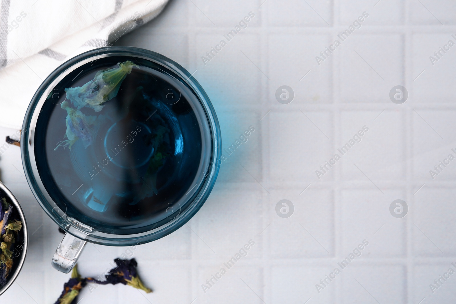 Delicious butterfly pea flower tea on white tiled table, flat lay. Space for text Photo of Delicious butterfly pea flower tea on white tiled table, flat lay. Space for text