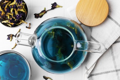 Delicious butterfly pea flower tea on white tiled table, flat lay